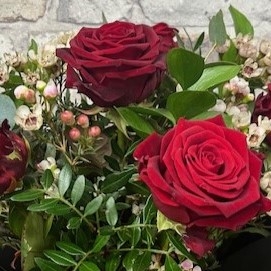 six red roses arranged in a vase by West Malling Flowers