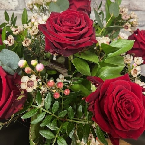 six red roses arranged in a vase by West Malling Flowers