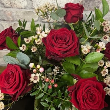 six red roses arranged in a vase by West Malling Flowers