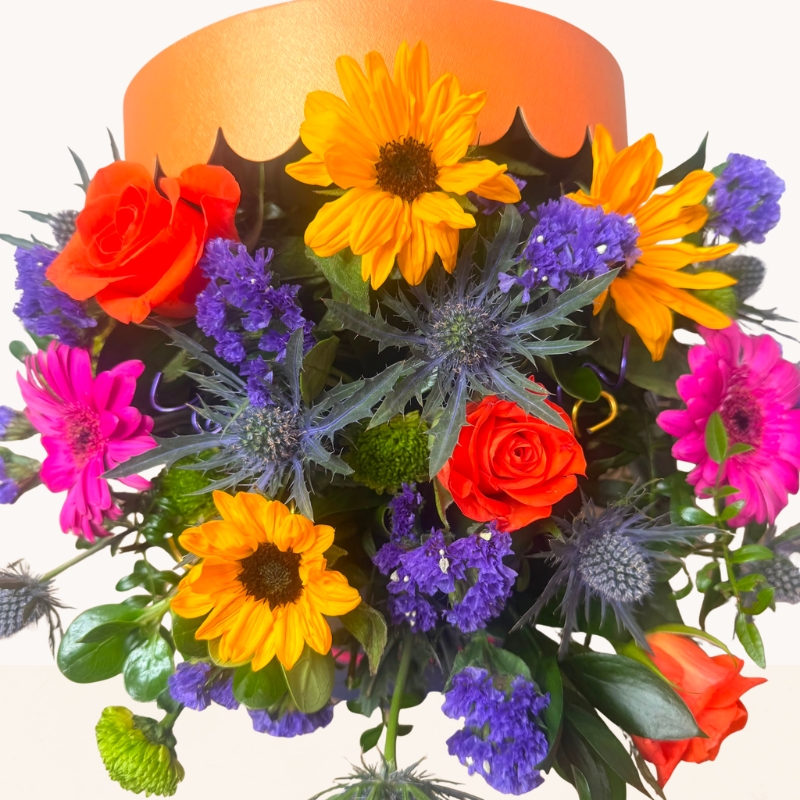 Summer Splash vibrant hat box arrangement with bright orange, pink, purple and blue seasonal flowers