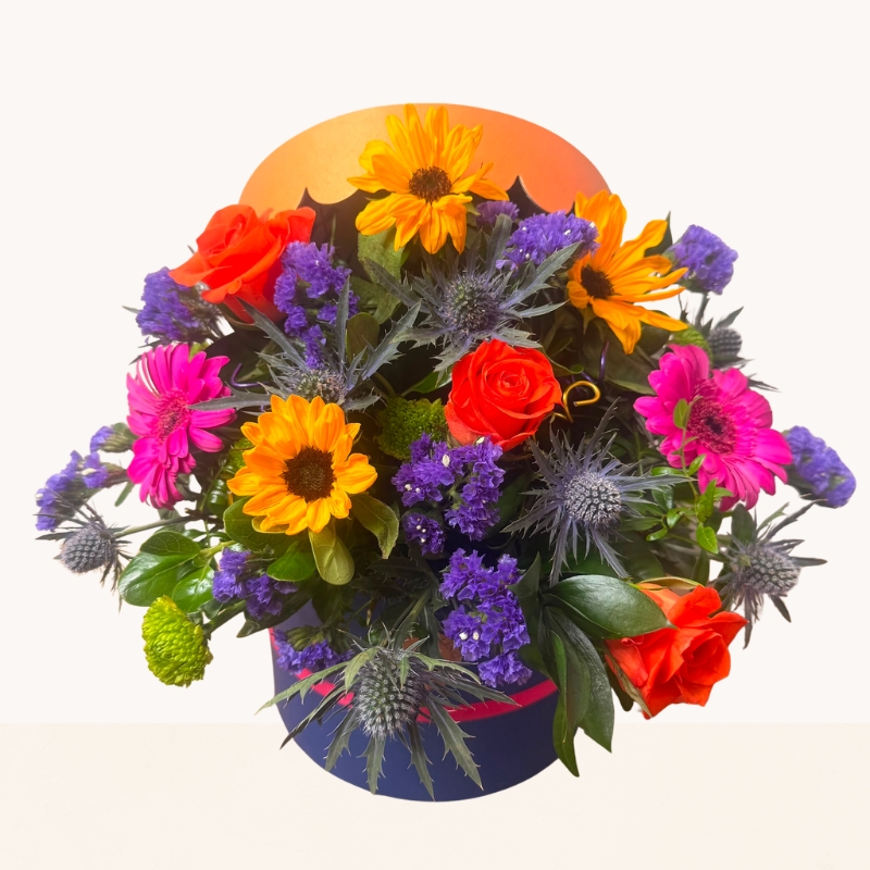Summer Splash vibrant hat box arrangement with bright orange, pink, purple and blue seasonal flowers