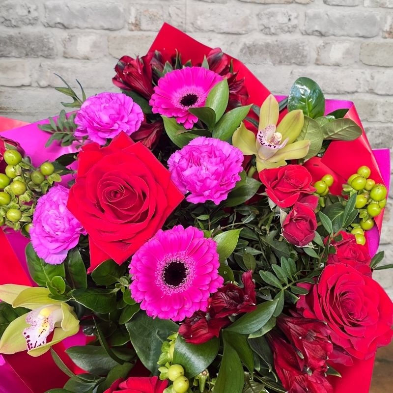 bold Valentine’s hand-tied bouquet with red and cerise flowers from West Malling Flowers
