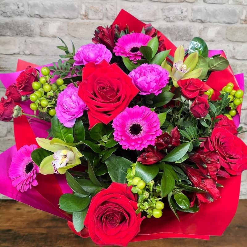 bold Valentine’s hand-tied bouquet with red and cerise flowers from West Malling Flowers