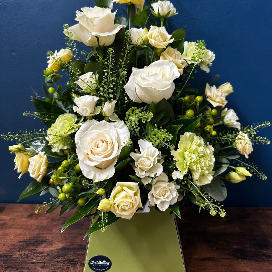 White sympathy flower box arrangement with front facing seasonal white flowers