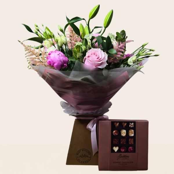 Luxury hand-tied bouquet featuring pink peonies, lilies, roses and seasonal flowers in soft pink, blush and ivory tones.