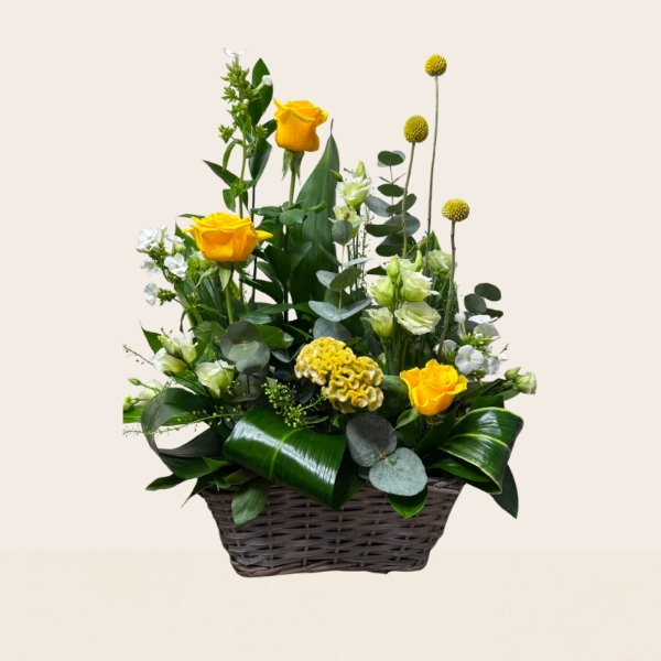 Rustic grey wash basket filled with yellow, white and lemon seasonal flowers, handcrafted by West Malling Flowers.