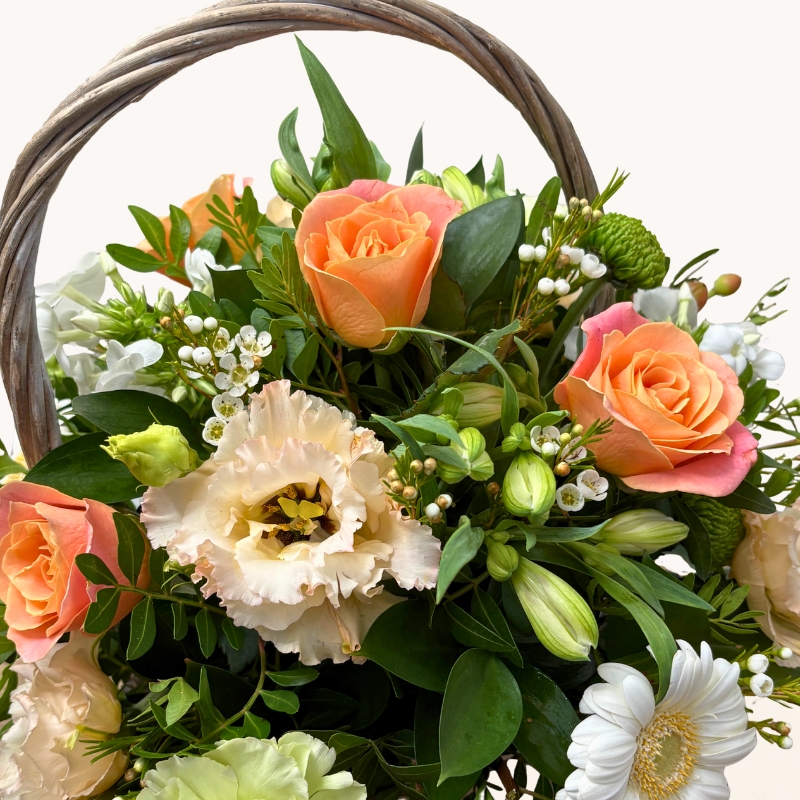 Summer Glow basket arrangement with peach, cream, white and green seasonal flowers by West Malling Flowers