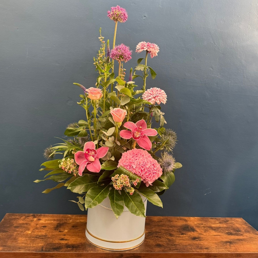 Pink hat box flower arrangement with seasonal flowers and modern styling