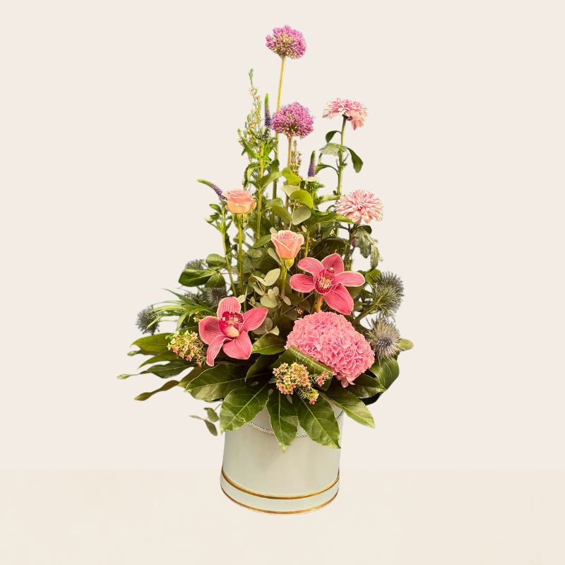 Pink hat box flower arrangement with seasonal flowers and modern styling
