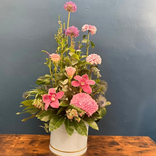 Pink hat box flower arrangement with seasonal flowers and modern styling
