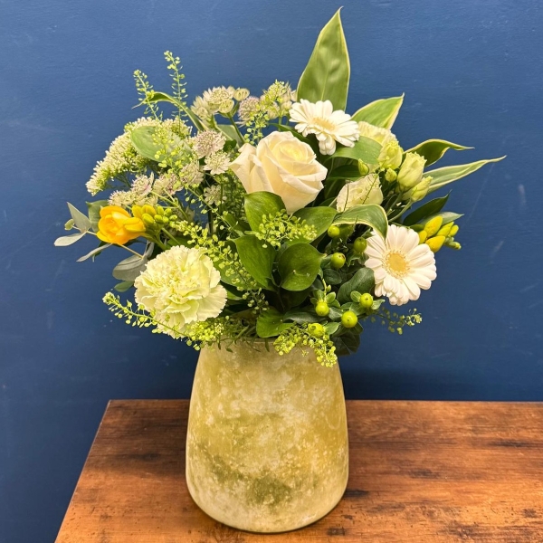 Yellow and white spring flowers arranged in decorative lemon vase