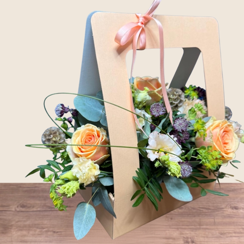Birthday living flower card arrangement with peach roses, cream lisianthus and seasonal flowers presented in a card-style floral gift.