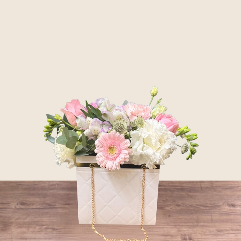 Mother’s Day flower arrangement in a white handbag gift container with soft pastel blooms, Paris collection West Malling florist