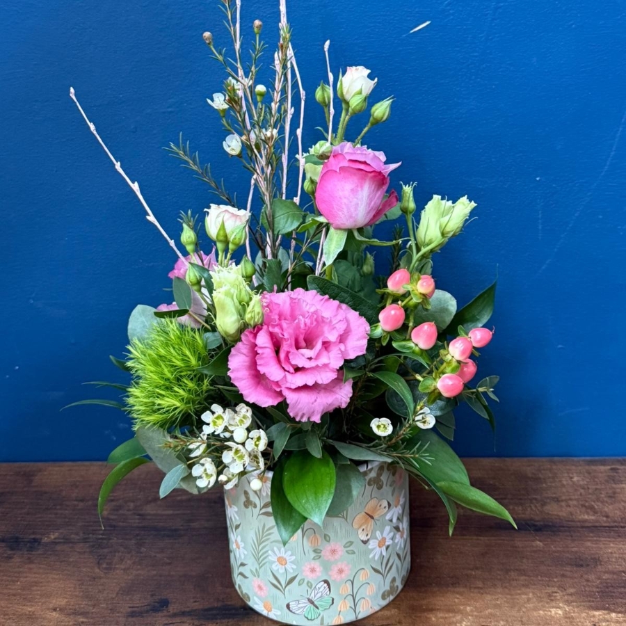 Pink green and white spring flowers arranged in a reusable ceramic pot