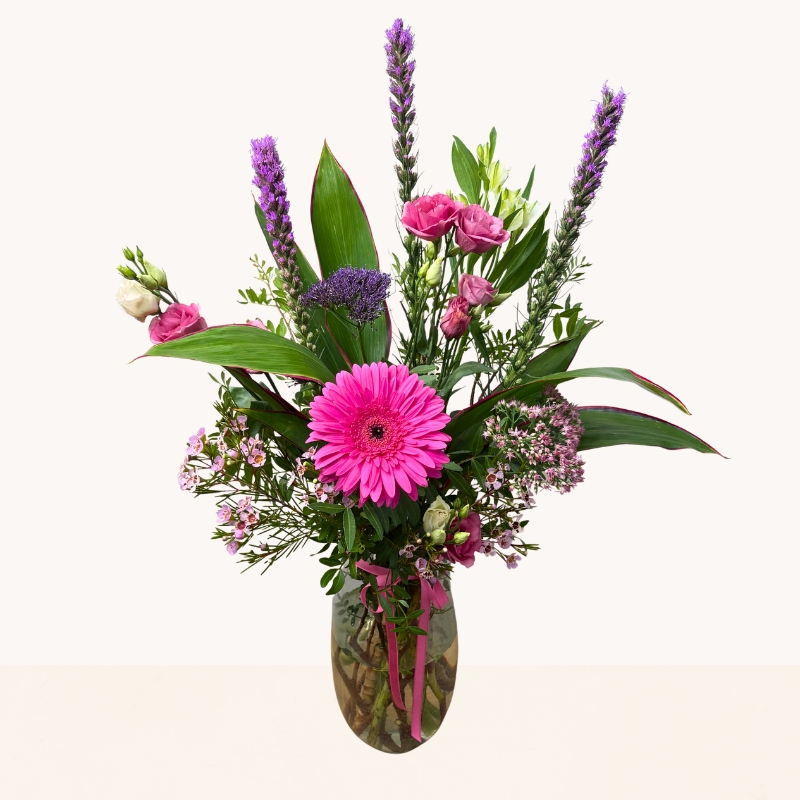 Summer Splash glass vase arrangement with vibrant pink and purple seasonal flowers by West Malling Flowers