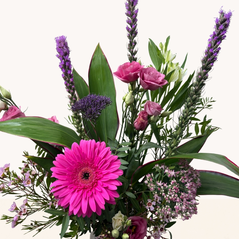 Summer Splash glass vase arrangement with vibrant pink and purple seasonal flowers by West Malling Flowers