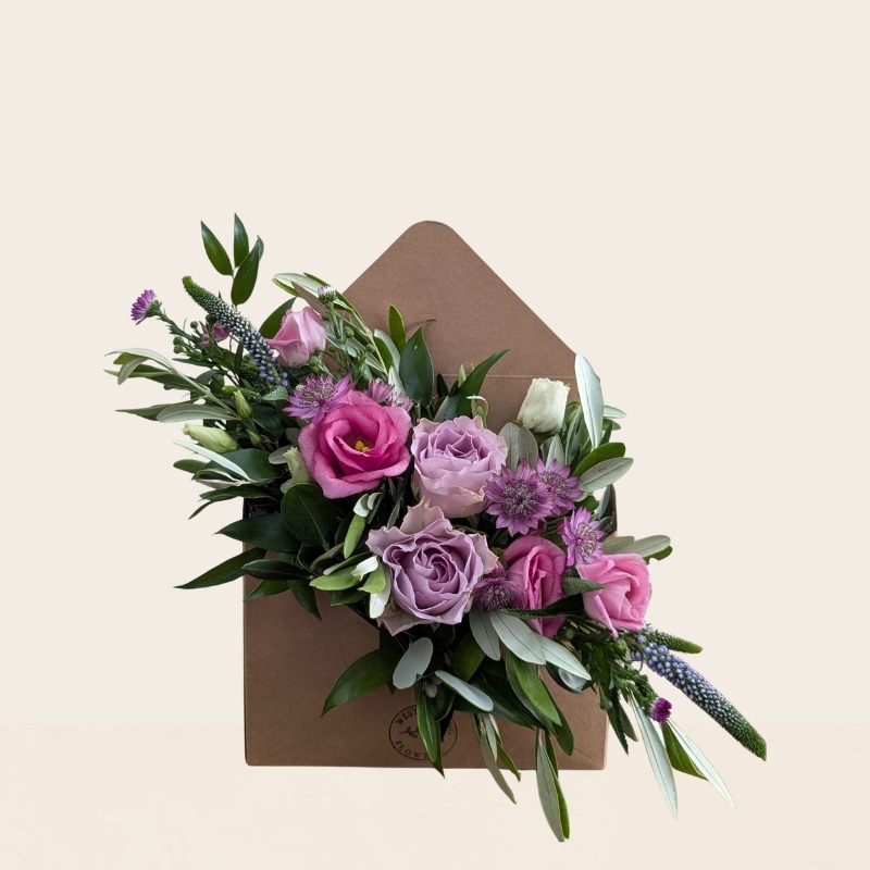 Pastel summer flower arrangement in kraft envelope with pink and lilac seasonal flowers