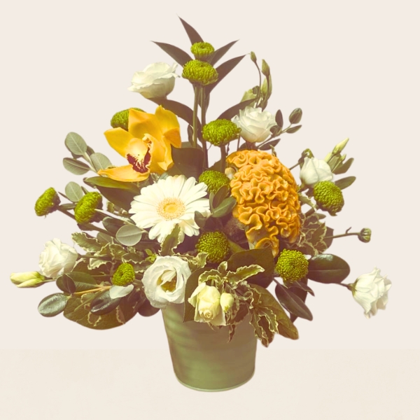 Summer flower arrangement in a zinc pot featuring fresh yellow, lemon and white seasonal flowers with mixed foliage.