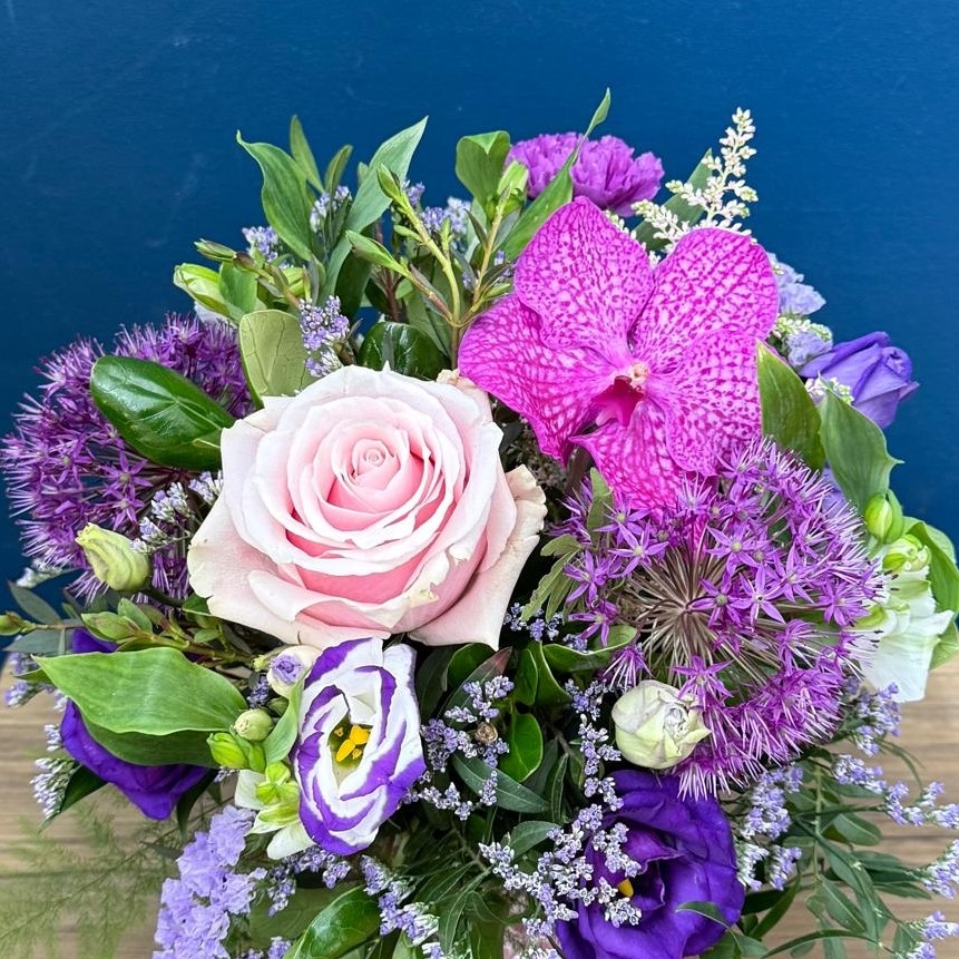 Summer flower arrangement in ceramic clay pot with pink heart design and pastel pink purple flowers