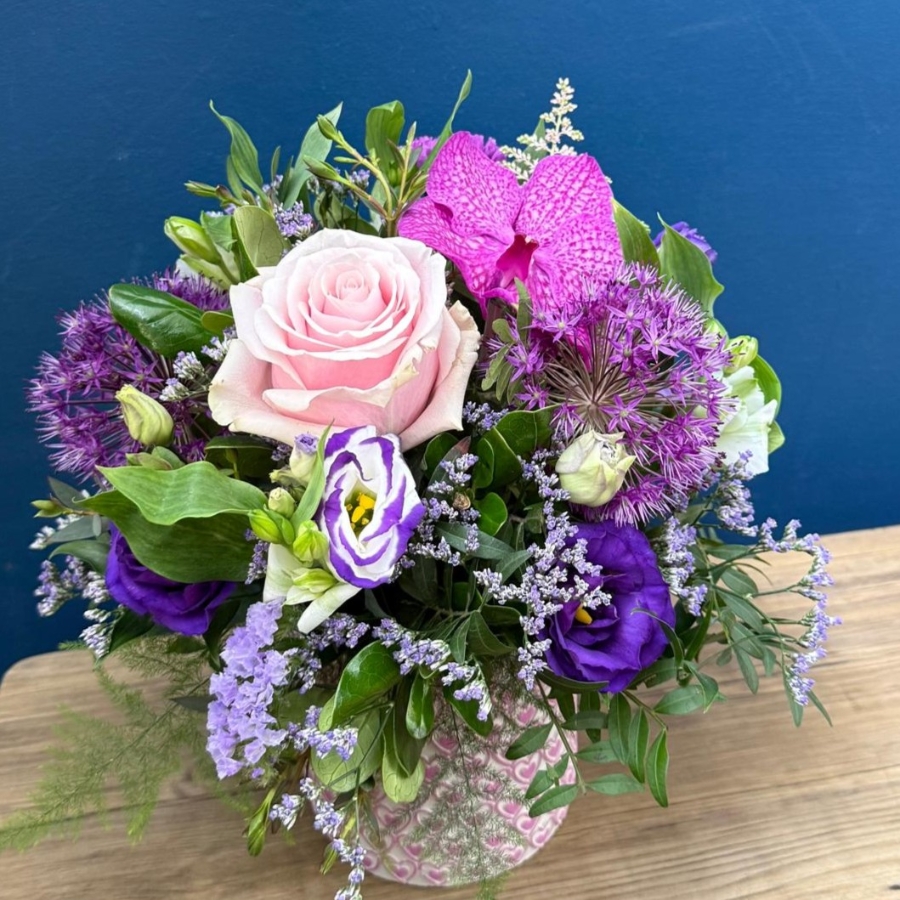 Summer flower arrangement in ceramic clay pot with pink heart design and pastel pink purple flowers