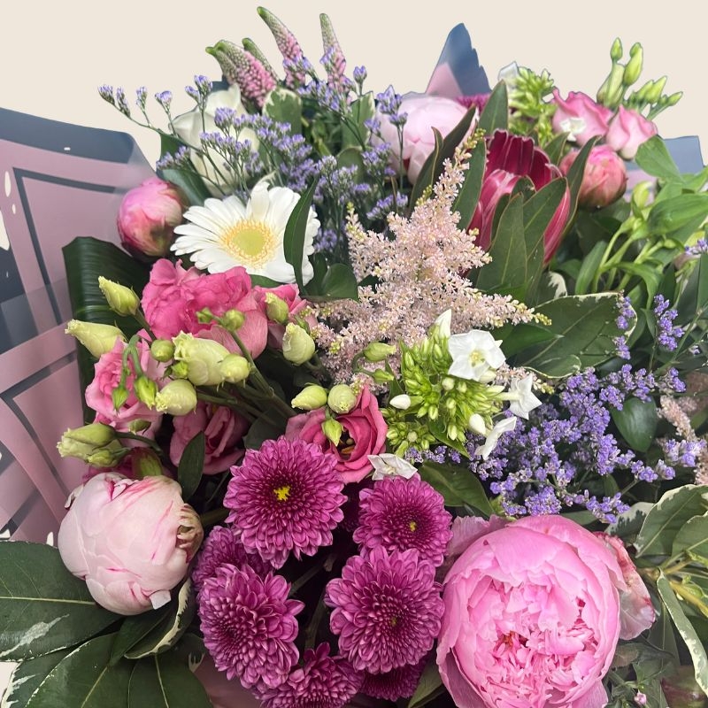 Luxury hand-tied bouquet featuring pink peonies, white flowers and lilac seasonal flowers arranged in a romantic garden style.