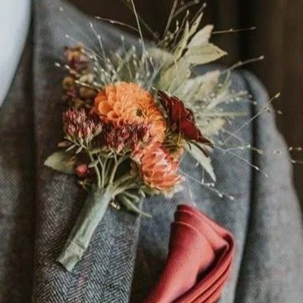 Rustic wedding buttonhole with seasonal flowers and natural foliage