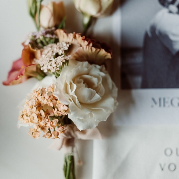 Pinned wedding corsage with seasonal flowers in rich tones
