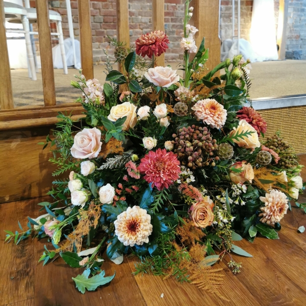 Large pastel pedestal flower arrangement for wedding ceremony