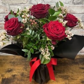 six red roses arranged in a vase by West Malling Flowers