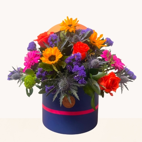 Summer Splash vibrant hat box arrangement with bright orange, pink, purple and blue seasonal flowers