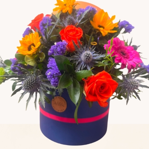 Summer Splash vibrant hat box arrangement with bright orange, pink, purple and blue seasonal flowers