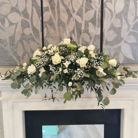 White top table flower arrangement with white and ivory seasonal flowers