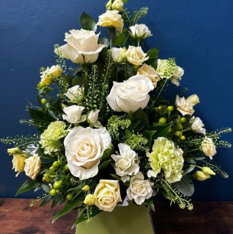 White sympathy flower box arrangement with front facing seasonal white flowers