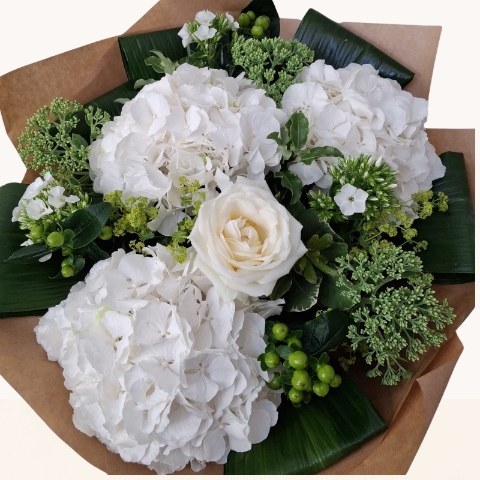 Luxury white hydrangea bouquet with seasonal white flowers and fresh green foliage.