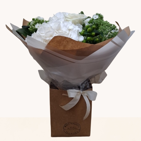 Luxury white hydrangea bouquet with seasonal white flowers and fresh green foliage.