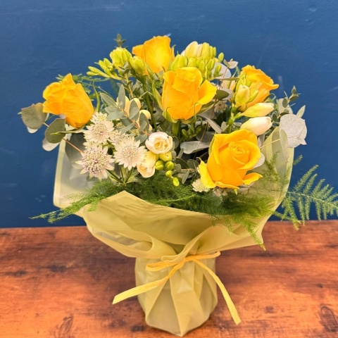Spring flowers in glass vase with yellow and white seasonal flowers