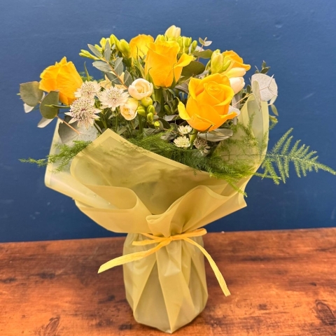 Spring flowers in glass vase with yellow and white seasonal flowers