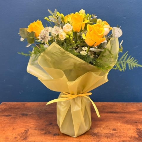 Spring flowers in glass vase with yellow and white seasonal flowers