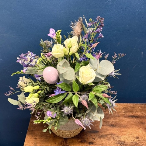 Spring flower basket arrangement with pink white and lilac seasonal flowers