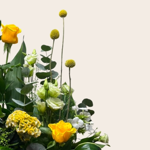 Rustic grey wash basket filled with yellow, white and lemon seasonal flowers, handcrafted by West Malling Flowers.