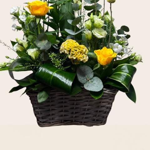 Rustic grey wash basket filled with yellow, white and lemon seasonal flowers, handcrafted by West Malling Flowers.