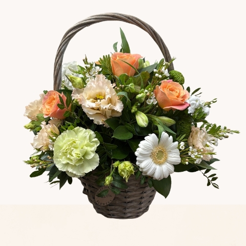 Summer Glow basket arrangement with peach, cream, white and green seasonal flowers by West Malling Flowers