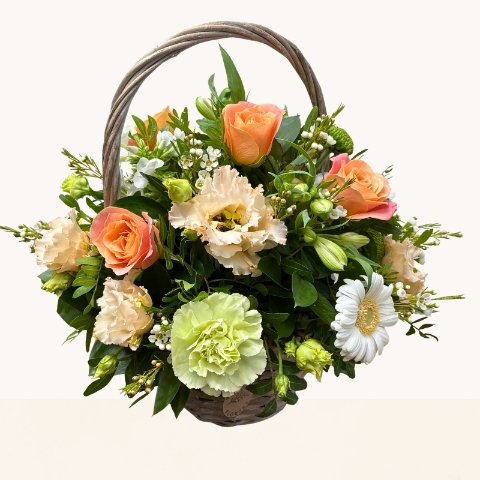 Summer Glow basket arrangement with peach, cream, white and green seasonal flowers by West Malling Flowers