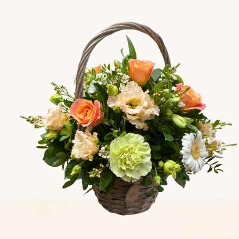 Summer Glow basket arrangement with peach, cream, white and green seasonal flowers by West Malling Flowers