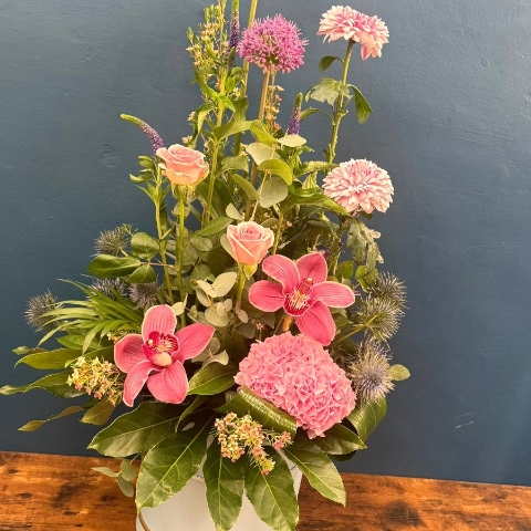 Pink hat box flower arrangement with seasonal flowers and modern styling