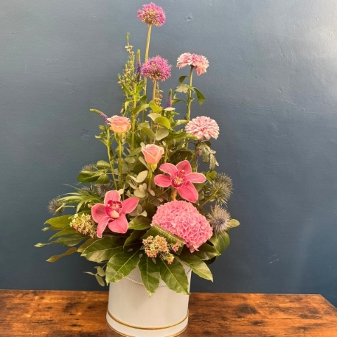 Pink hat box flower arrangement with seasonal flowers and modern styling