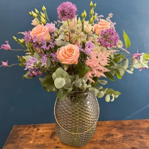 Pastel flower arrangement in glass lantern vase with gold frame tealight holder