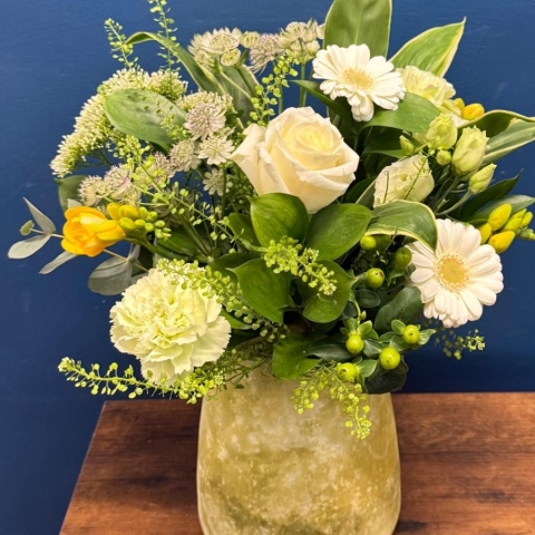 Yellow and white spring flowers arranged in decorative lemon vase