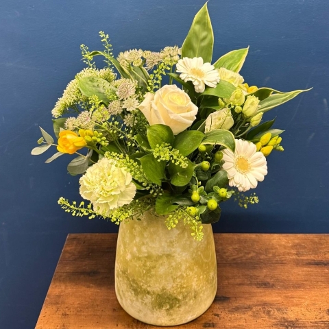 Yellow and white spring flowers arranged in decorative lemon vase