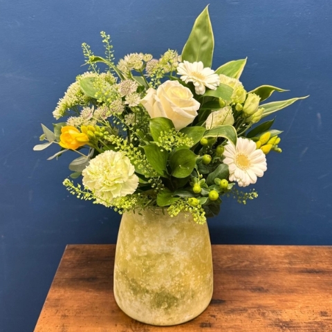 Yellow and white spring flowers arranged in decorative lemon vase